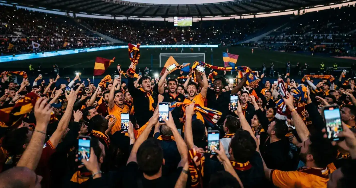 Navijači v polnem stadionu gledajo v telefone in vzklikajo